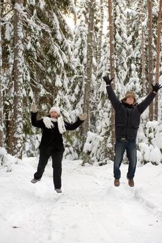 Happy middle-aged couple jumping on a winter day 
