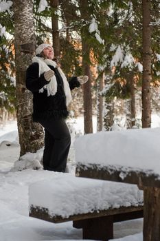 Happy middle-aged women having fun on winters day in forest.