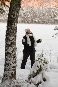 Happy middle-aged women having fun on winters day in forest.