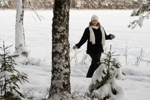 Happy middle-aged women having fun on winters day in forest.