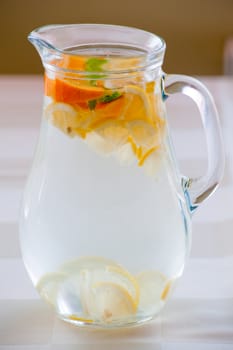 Jug of cold water with lemon and orange slices