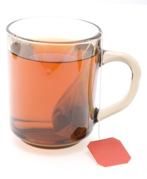 glass teacup with  tea bag on white background