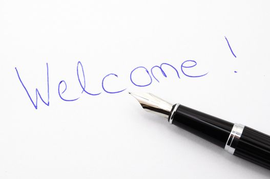welcome message on sheet of paper with pen