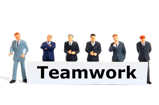 team or teamwork business concept with tiny toy business man isolated on white background