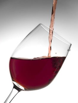 A malbec glass being poured with red wine.