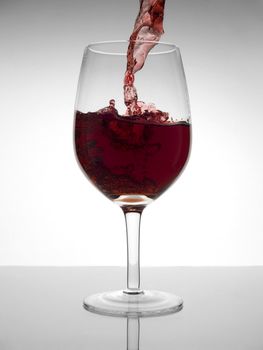 A malbec glass being poured with red wine.