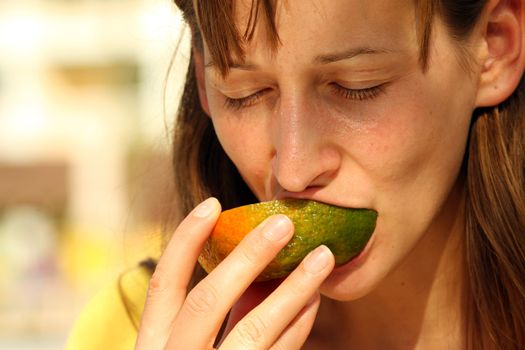 girl eating fresh and tasty fruit outdoor