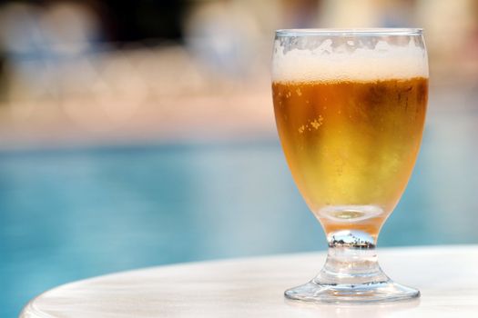 glass beer on the table by the pool