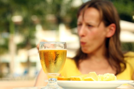 Dinner by the pool. Girl sitting on the background