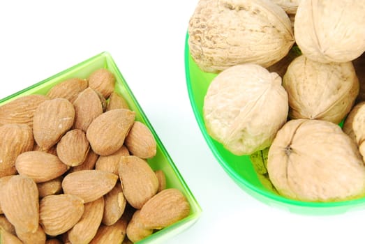 almond and walnuts on green cup's isolated on white background