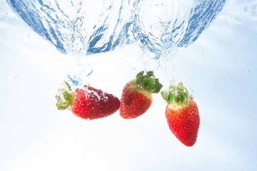 healthy strawberry fruits splashing in cool water