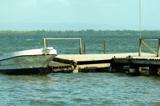 old wooden pier and white boat