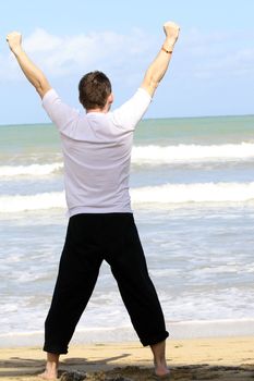 man doing breathing exercises on the beach