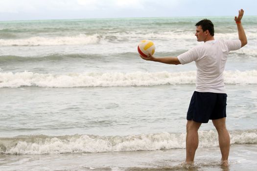 man holding volleyball and inviting to play