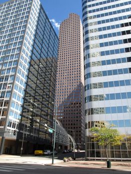 Glass Denver office buildings rise into a bright blue sky