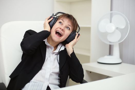 Emotional woman listening to loud music with big headphones