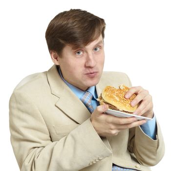 The funny young businessman eats a sandwich isolated on a white background