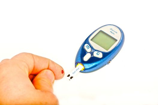 A person with diabetes tests their blood glucose level, over white