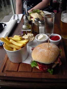 Huge burger served with chips and three different sauces