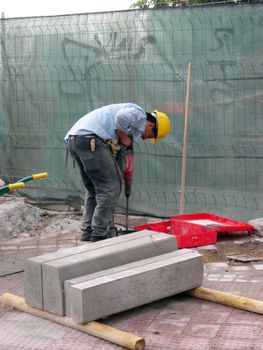 A worker using an electric hammer.