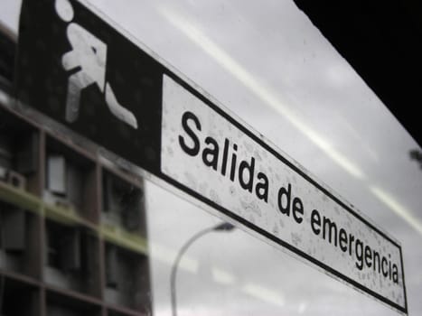 Emergency exit signal on a glass window inside a bus.