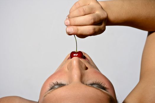 Upper View Of A Woman Tasting A Cherry