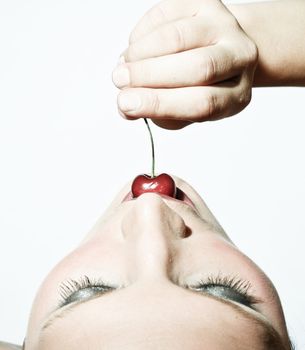 Upper View Of A Woman Tasting A Cherry In Contrast