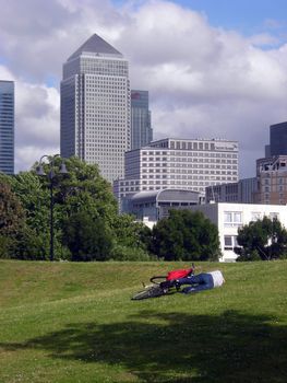 A solitaire cyclist resting on a park near Canary Wharf.