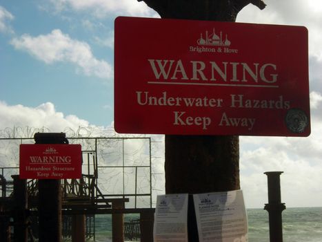 Warning signs at the shattered pier of Brighton, East Sussex