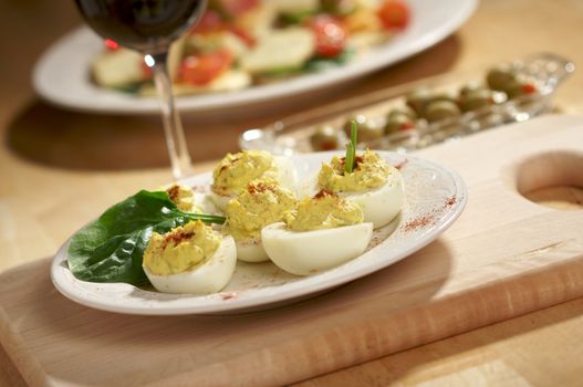 Deviled Eggs and Appetizers on a Decorative White Plate.