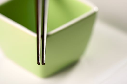 Chopsticks & Green Bowl on a white background.