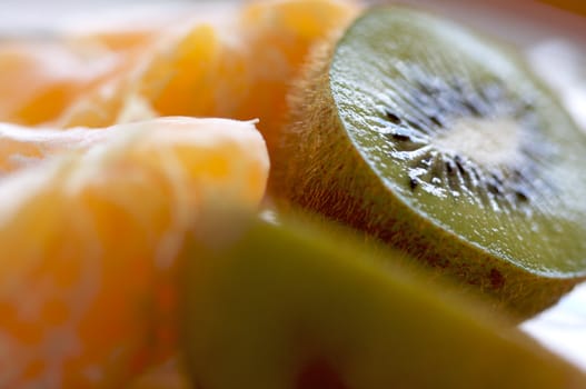 Kiwi and Clementine Tangerines on a plate in early morning light.