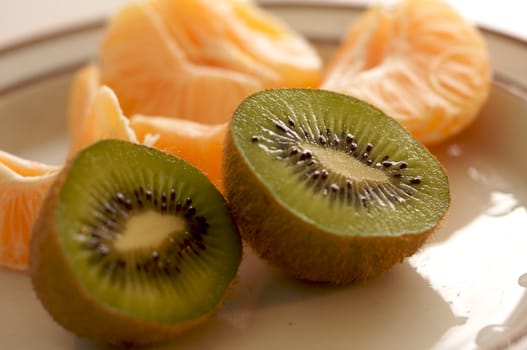 Kiwi and Clementine Tangerines on a plate in early morning light.