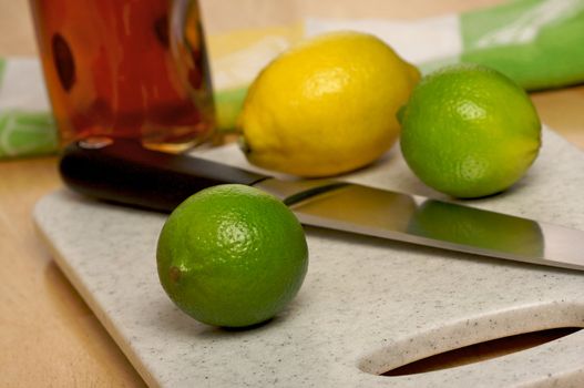 Limes, Lemons and Knife on Cutting Board