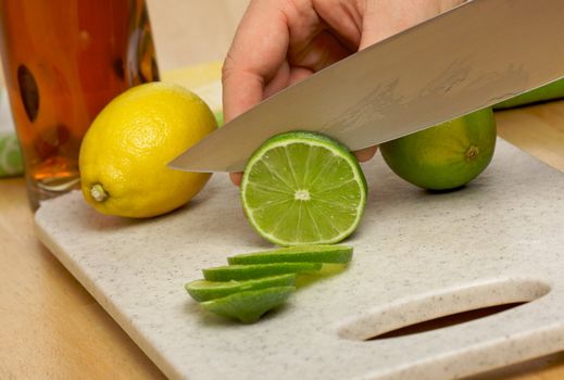 Slicing a lime on a cutting board.