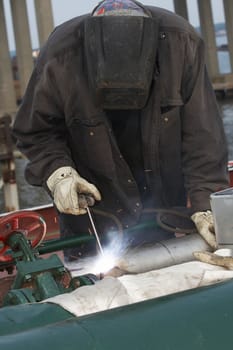 a welder working at shipyard during day shift
