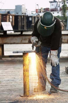 a welder working a torch at shipyard