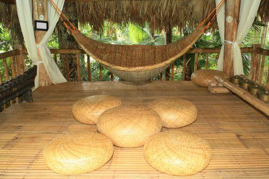 hammock and cushions made from native materials inside a hut
