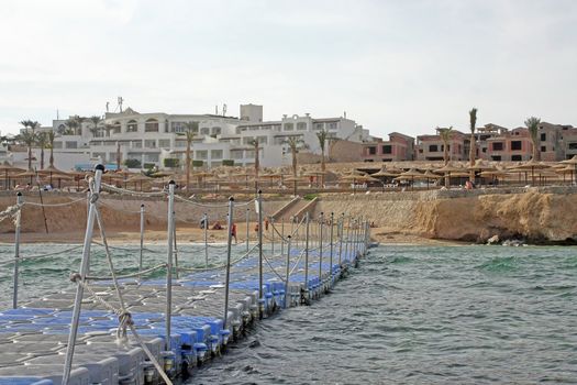 Egypt, Sharm-el-Sheikh, Red Sea. The beach is set a long pontoon in the sea.