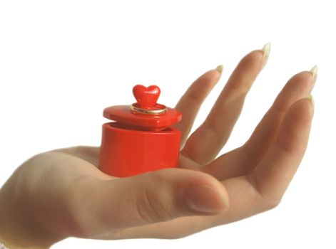 Wedding ring on the box in the form of a heart in the palm