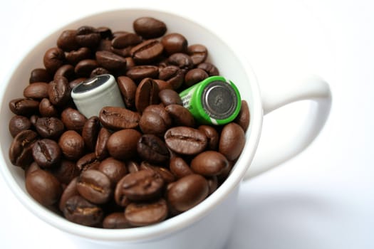 Two batteries in a cup with grains of coffee 