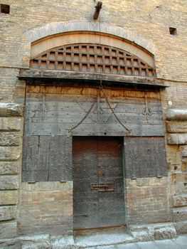 Ancient building door made of stone, iron and wood in Bologna