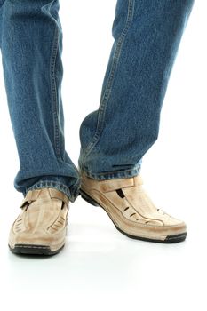 Human foot with brown leather shoes and jeans, isolated on white