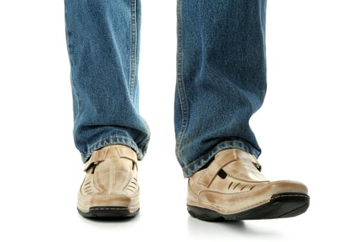 Human foot with brown leather shoes and jeans, isolated on white