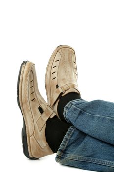 Human foot with brown leather shoes and jeans, isolated on white