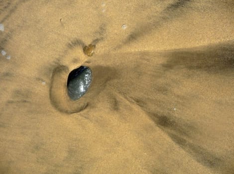 An abstract view of a stone in some beach sand.