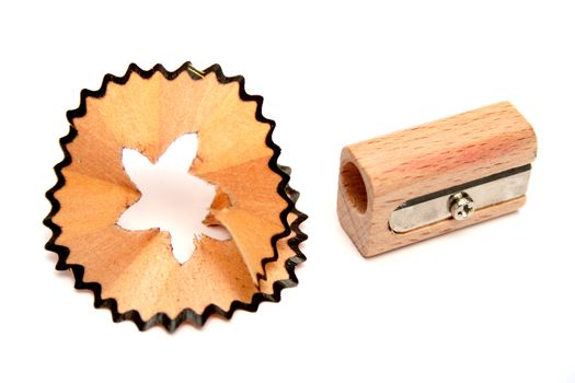 Wooden sharpener for pencils and a shaving on a white background