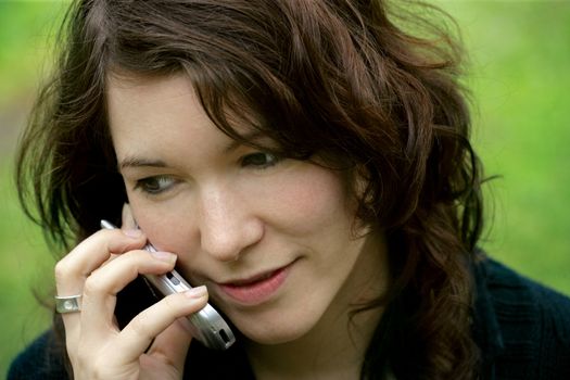 Headshot of a pretty female talking on her cellphone.
