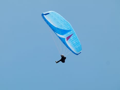 man paragliding over pure blue sky 