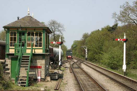 looking down the train tracks past a signal box